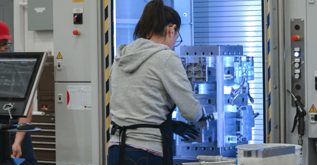 Machinist loads parts onto a CNC mill fixture
