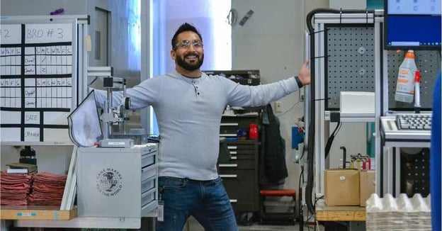 Machinist stands in front of CNC mill