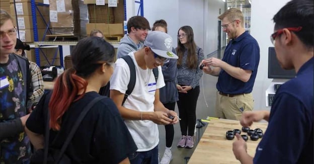 Engineer shows students prototype parts