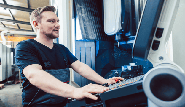 machinist programs G-code at a CNC mill