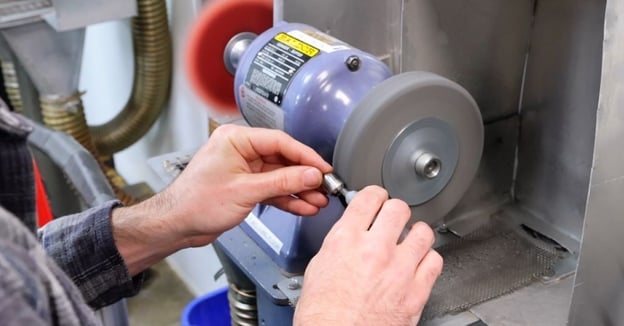 Production specialist manually polishes lathe component