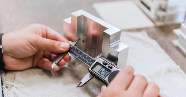 Engineer inspects a part with calipers