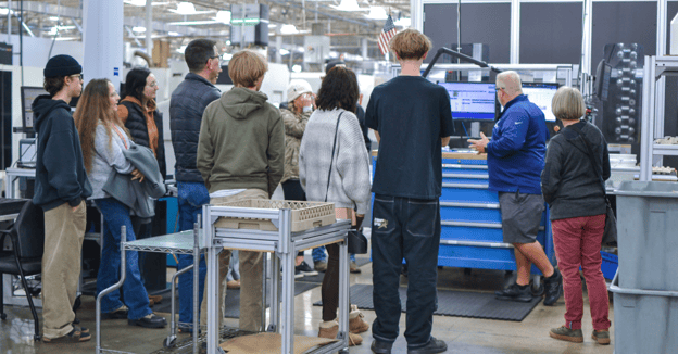 Machinist demonstrates inspection software to visiting students