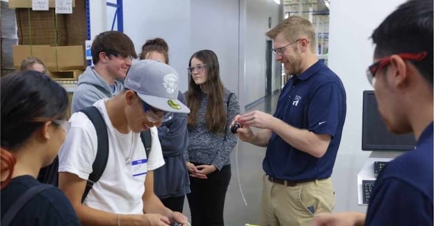 Engineer shows students prototype parts