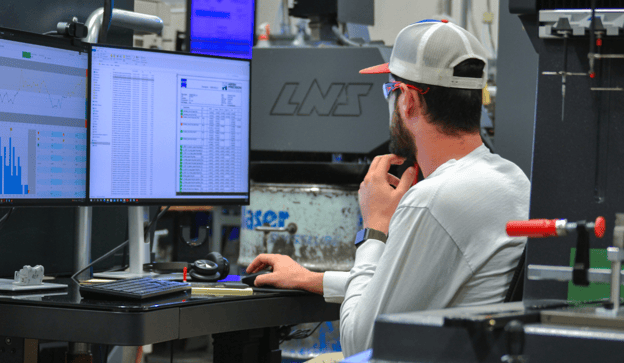 CNC machinist reviews inspection data on PC