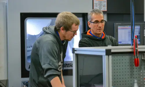 Machinists examine a part together