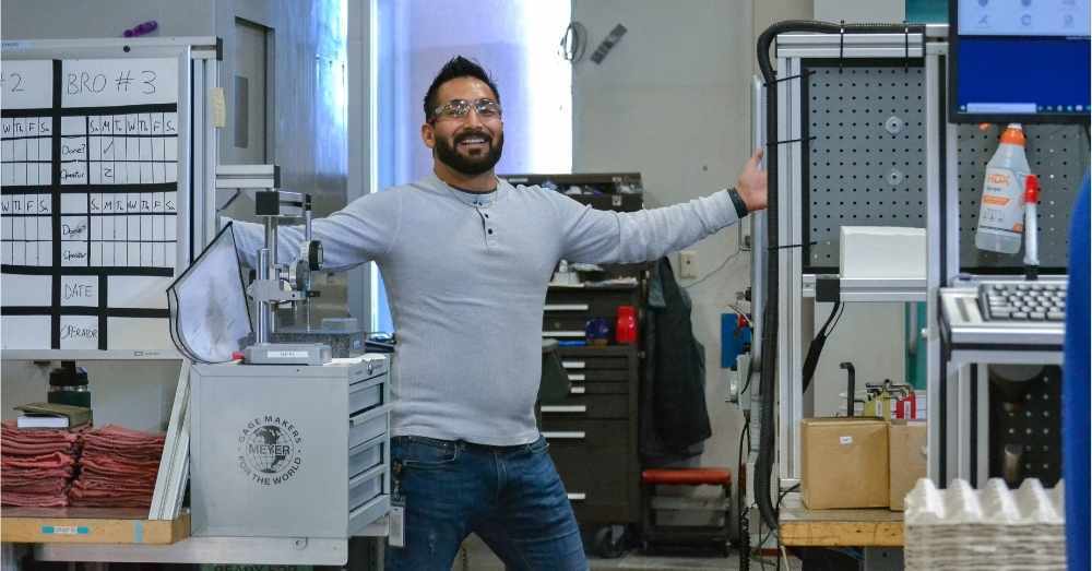 Machinist stands in front of CNC mill
