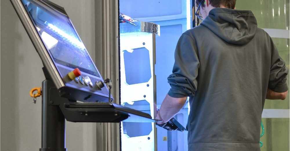 CNC machinist loads parts onto 5-axis mill fixture