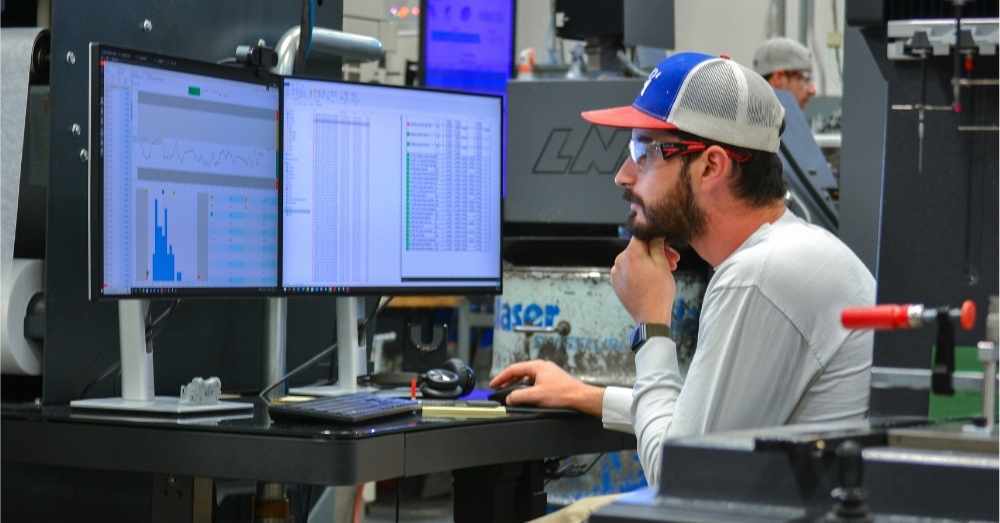 CNC machinist reviews inspection data on PC