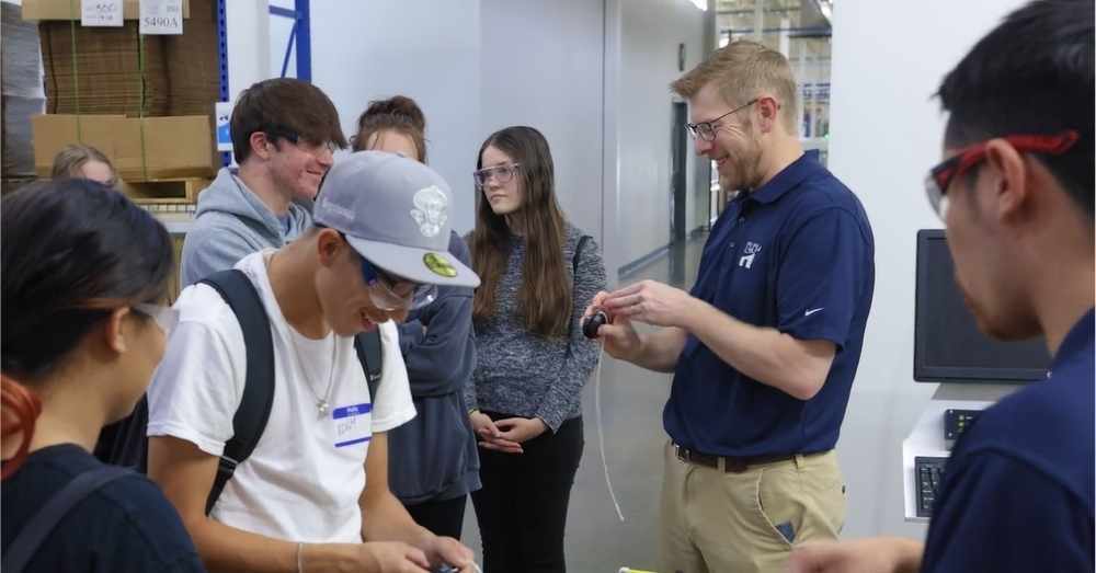 Engineer shows students prototype parts