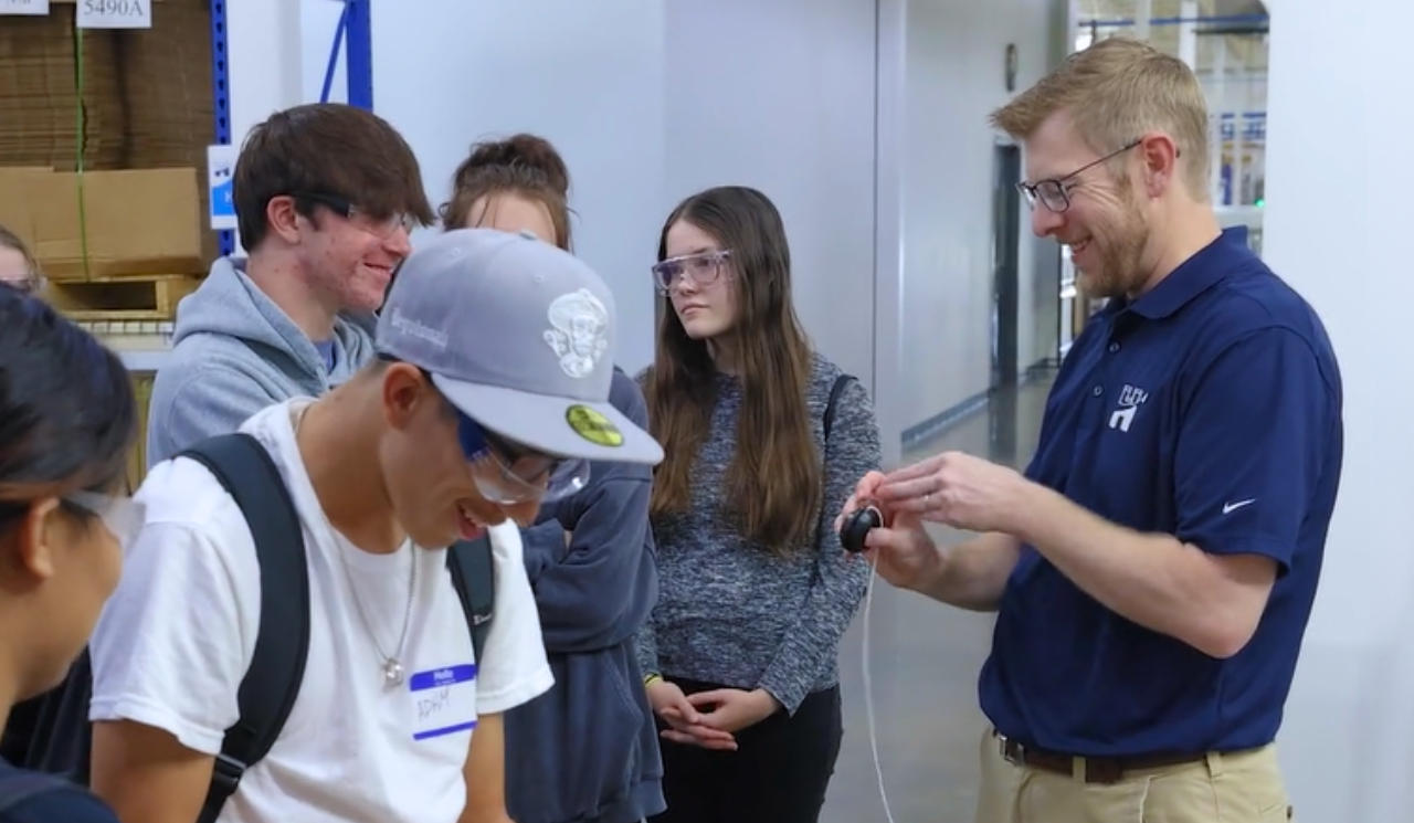 Engineer shows students demo parts