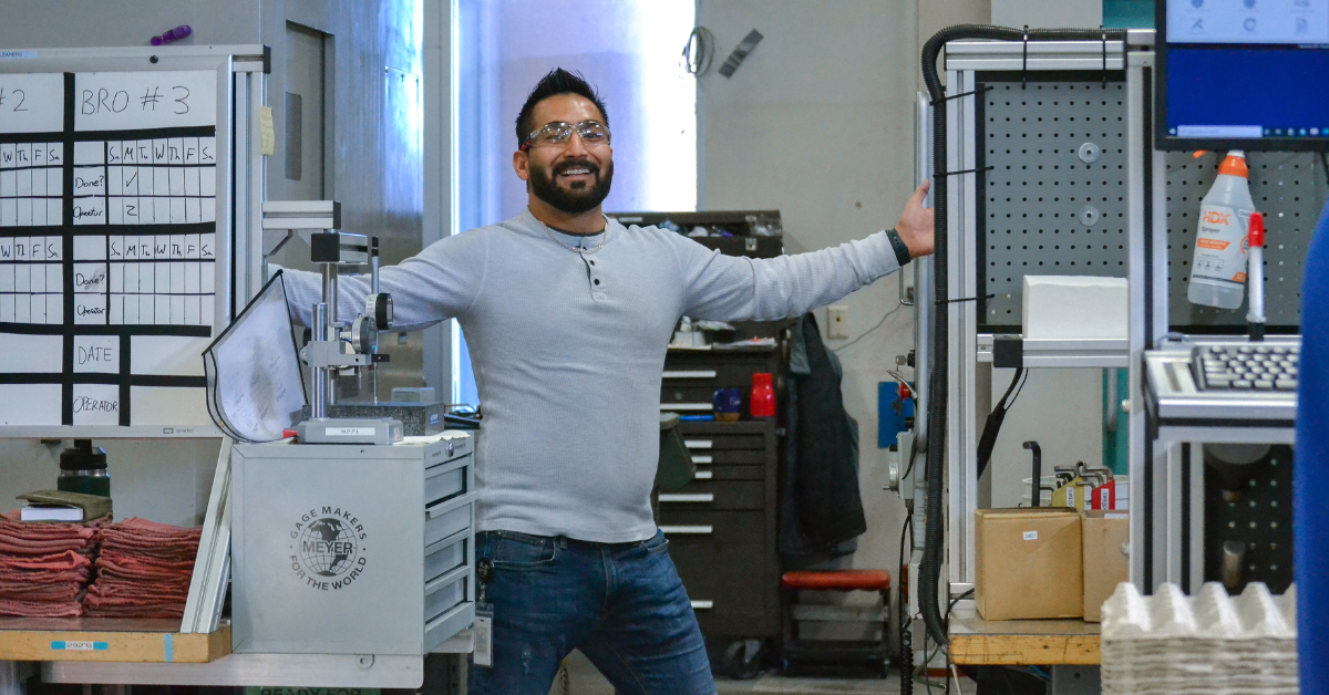 Machinist stands in front of CNC mill